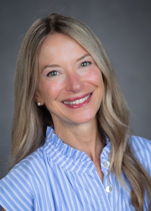 Dr. Karen Soul smiling. She has blonde hair and is wearing a blue dress.